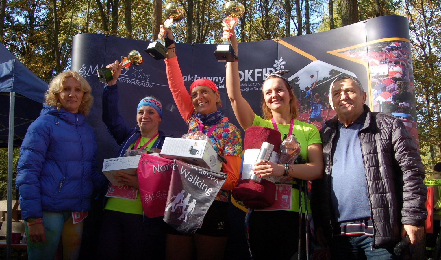 zadowolone zwyciężczynie w nordic walking wspólnie z organizatorami pozują na ściance
